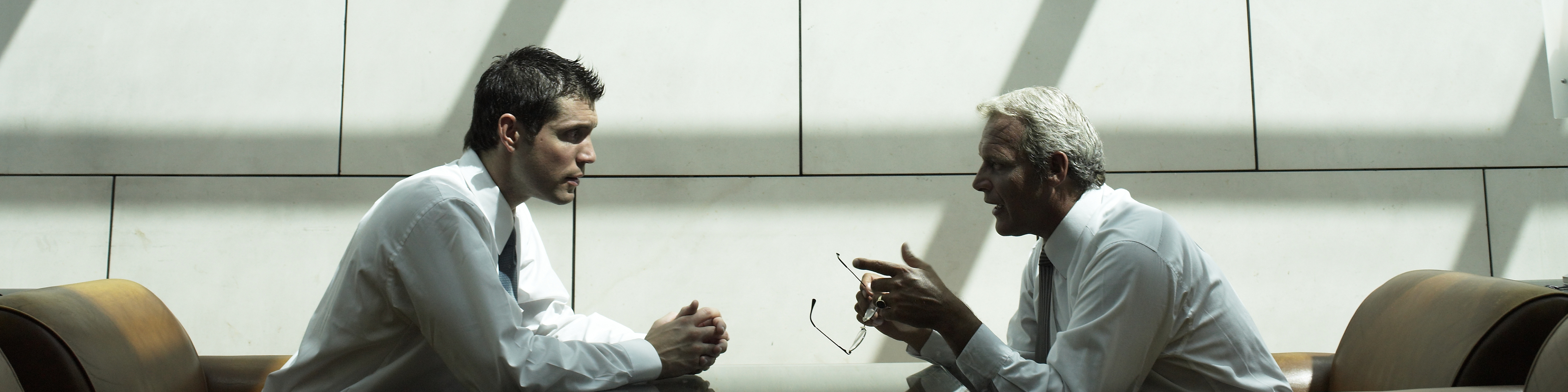 Two businessmen having discussion in hotel lobby, side view