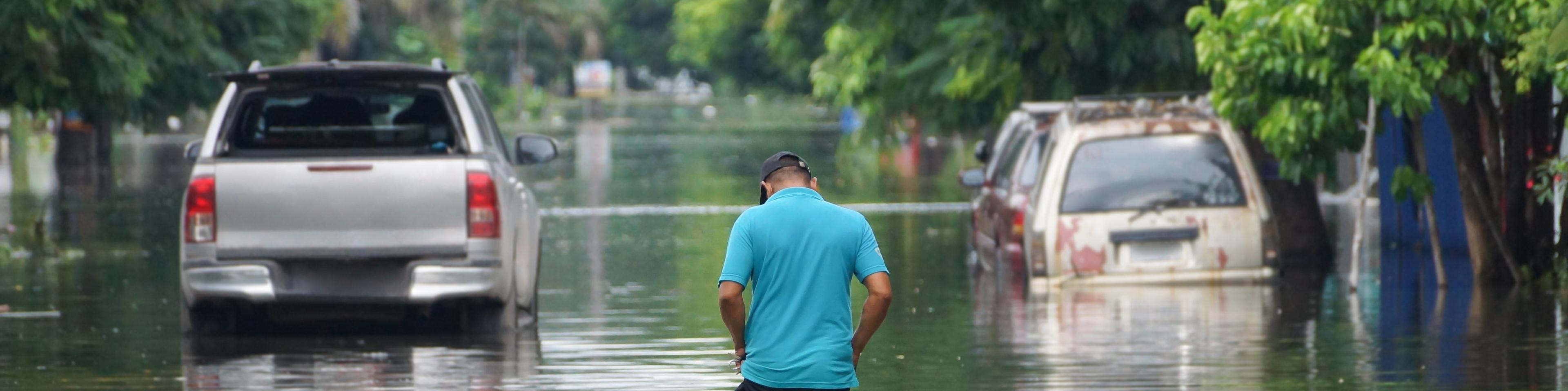 Man walking down a flooded street
