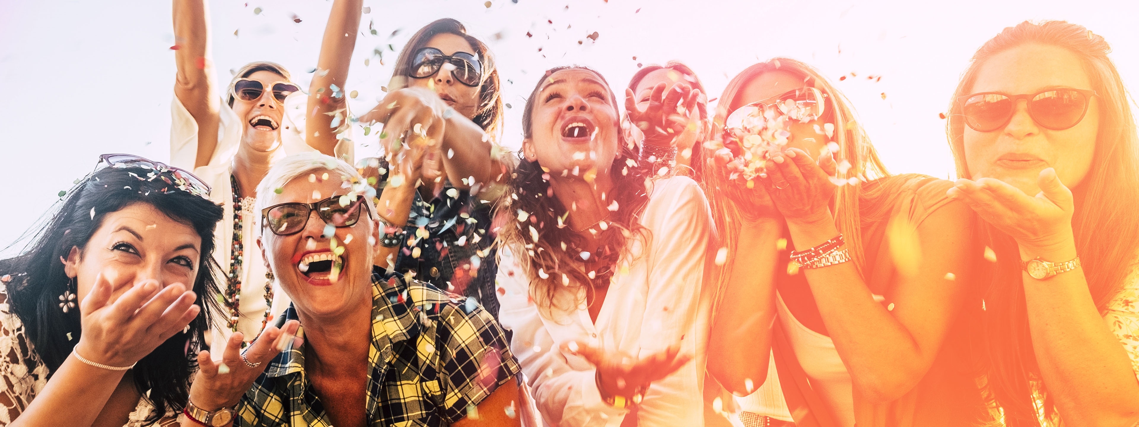 Group of people celebrating, cheering and throwing confetti