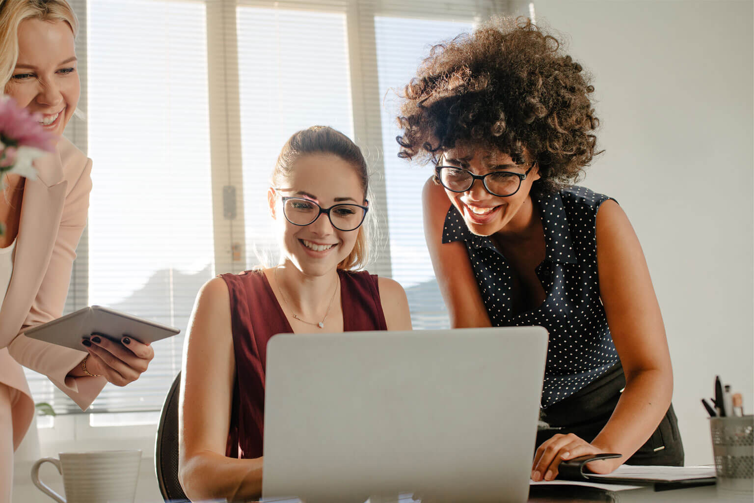 Three female professionals reading laptop