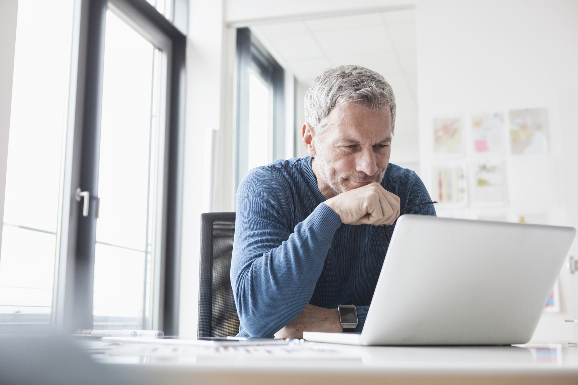 Smiling Man reading on Laptop