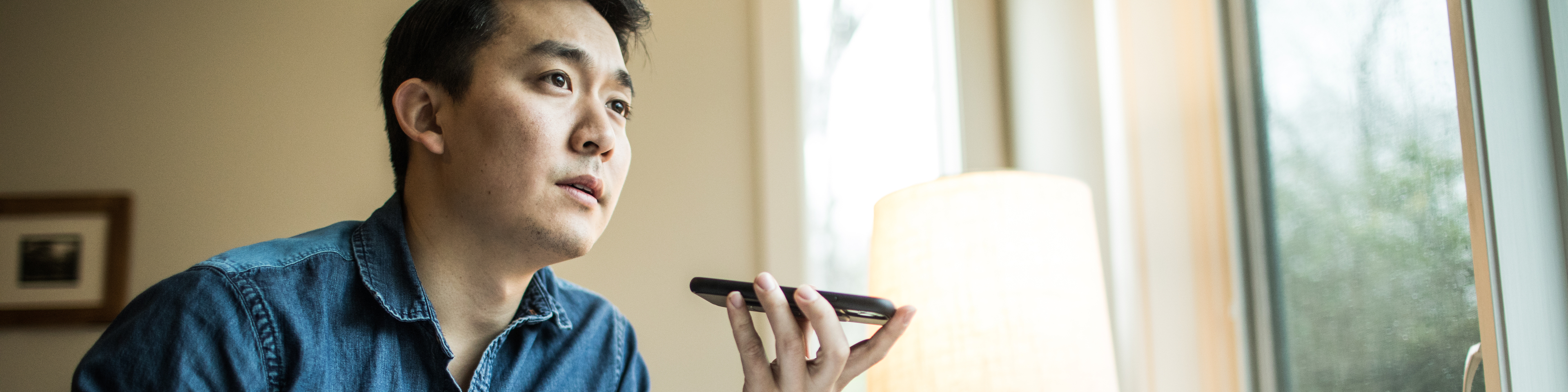 Man (early 30s) on phone working in home office