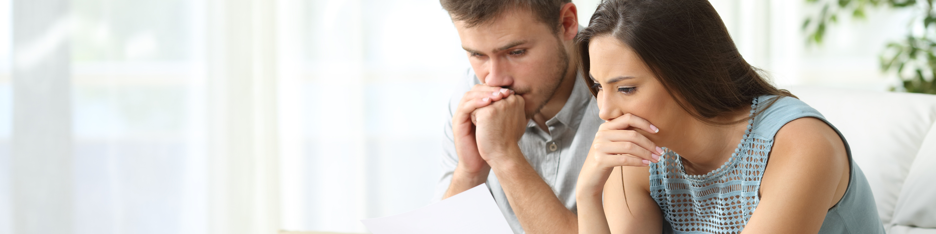 Worried couple reading a letter