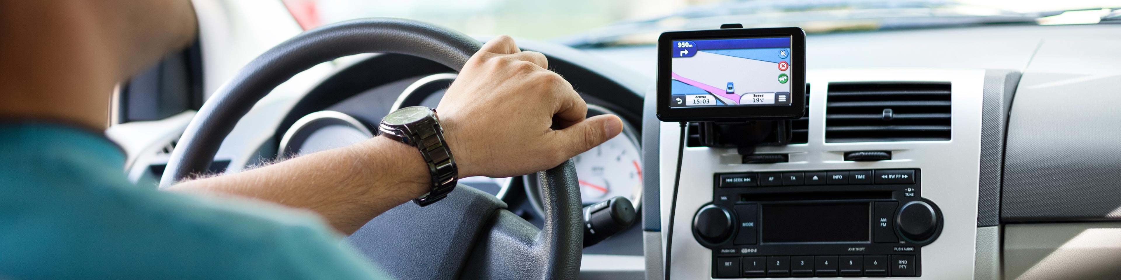 Man driving car looking at GPS