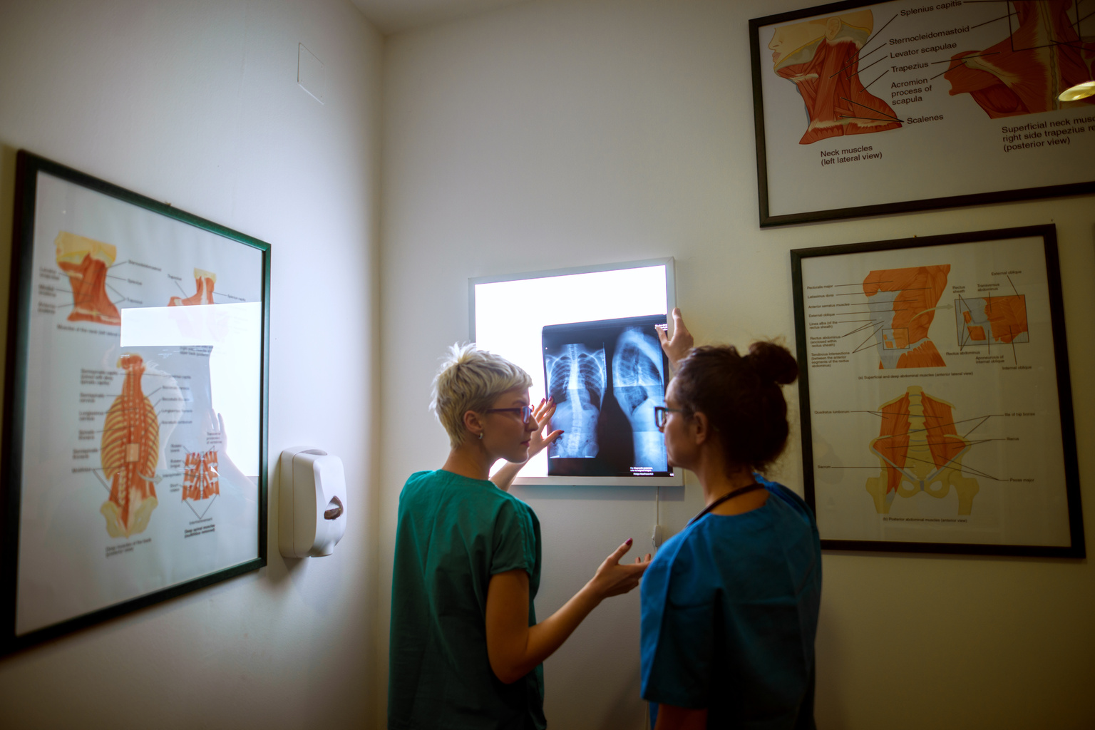 Two nurses reviewing medical imaging in exam room