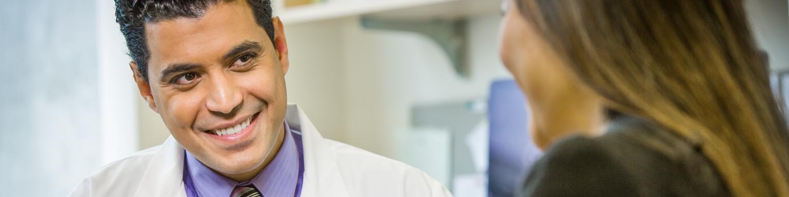 male doctor with tablet talking to female patient