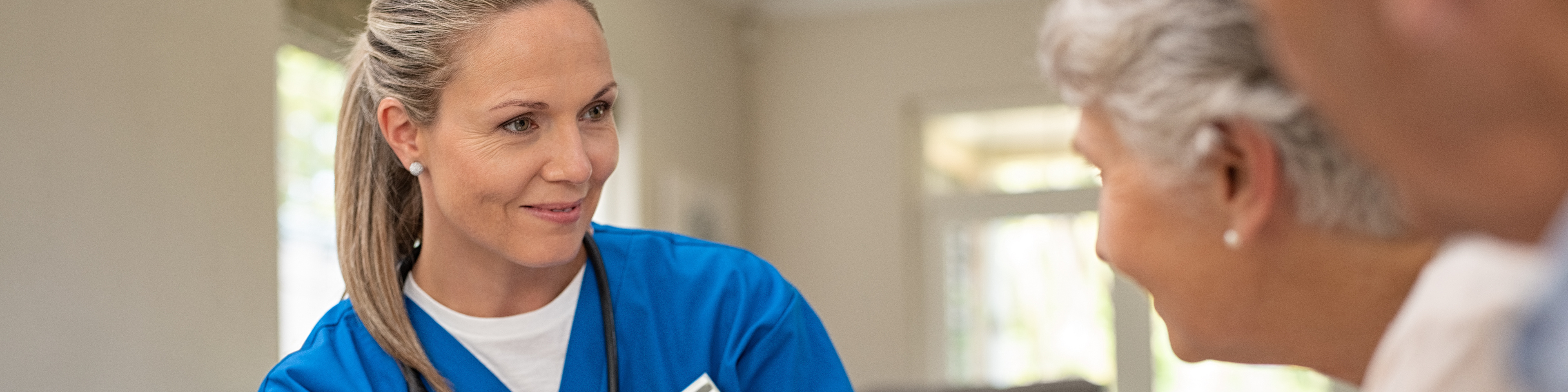 Friendly nurse talking with older couple