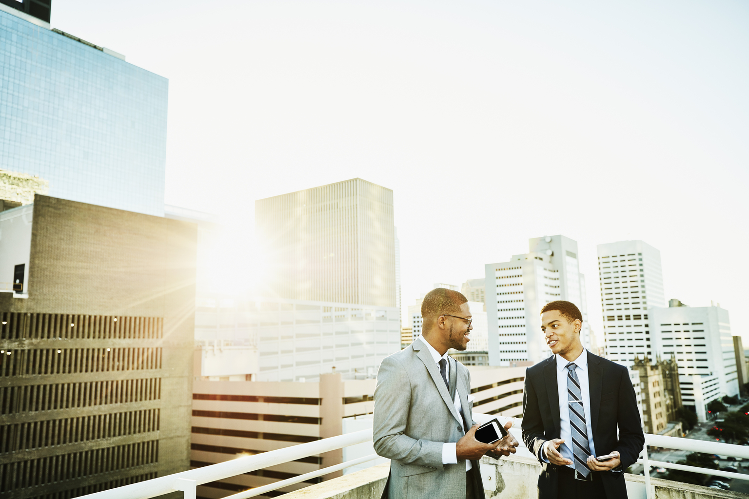 Two businessmen in discussion on downtown office deck