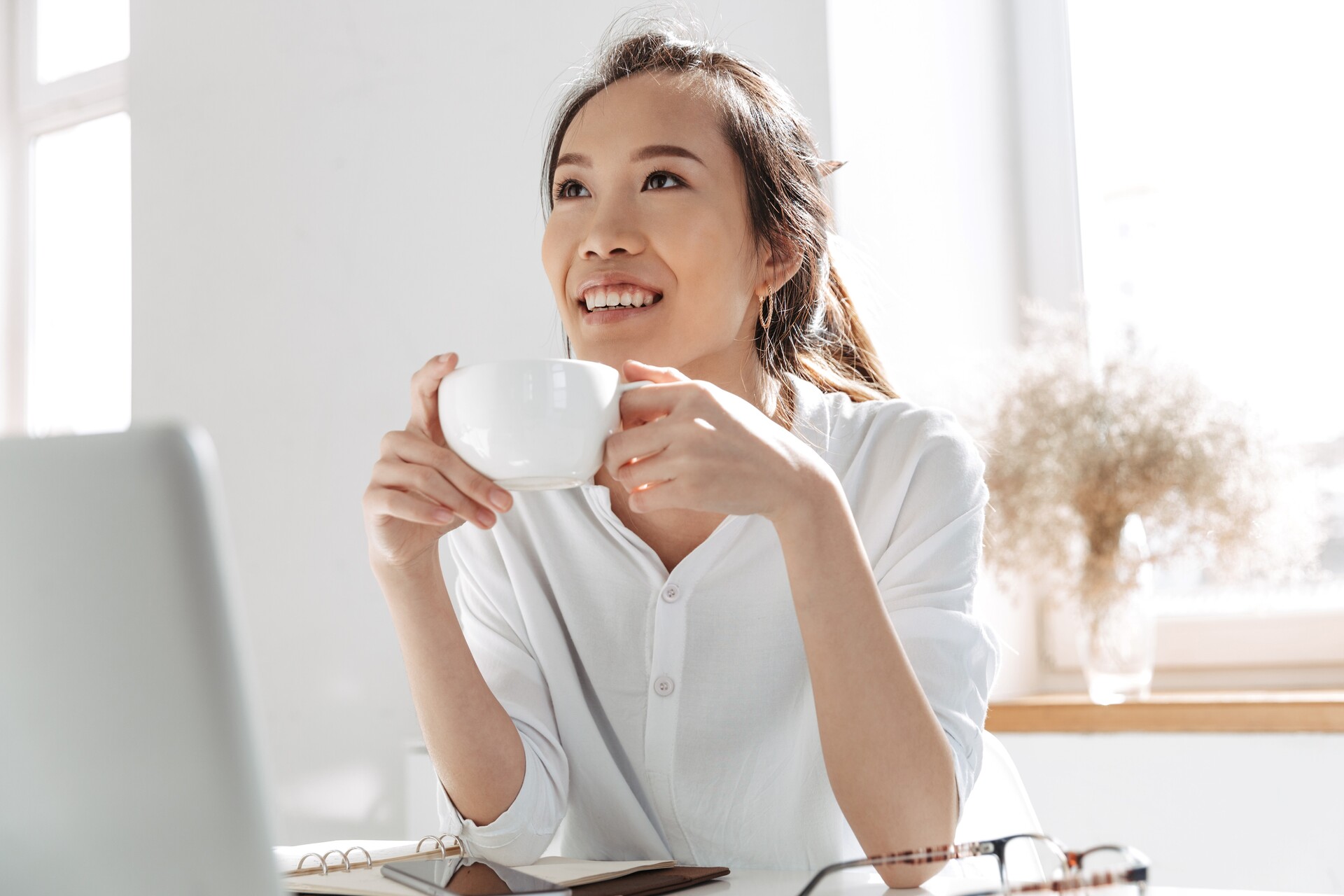 Accountant drink koffie achter laptop