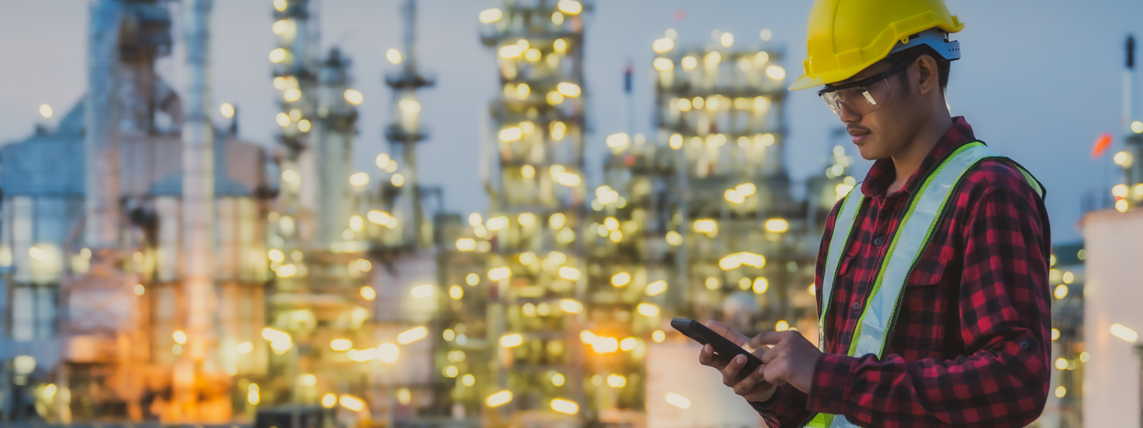 Asian man engineer working late night shift at petroleum oil refinery in industrial estate