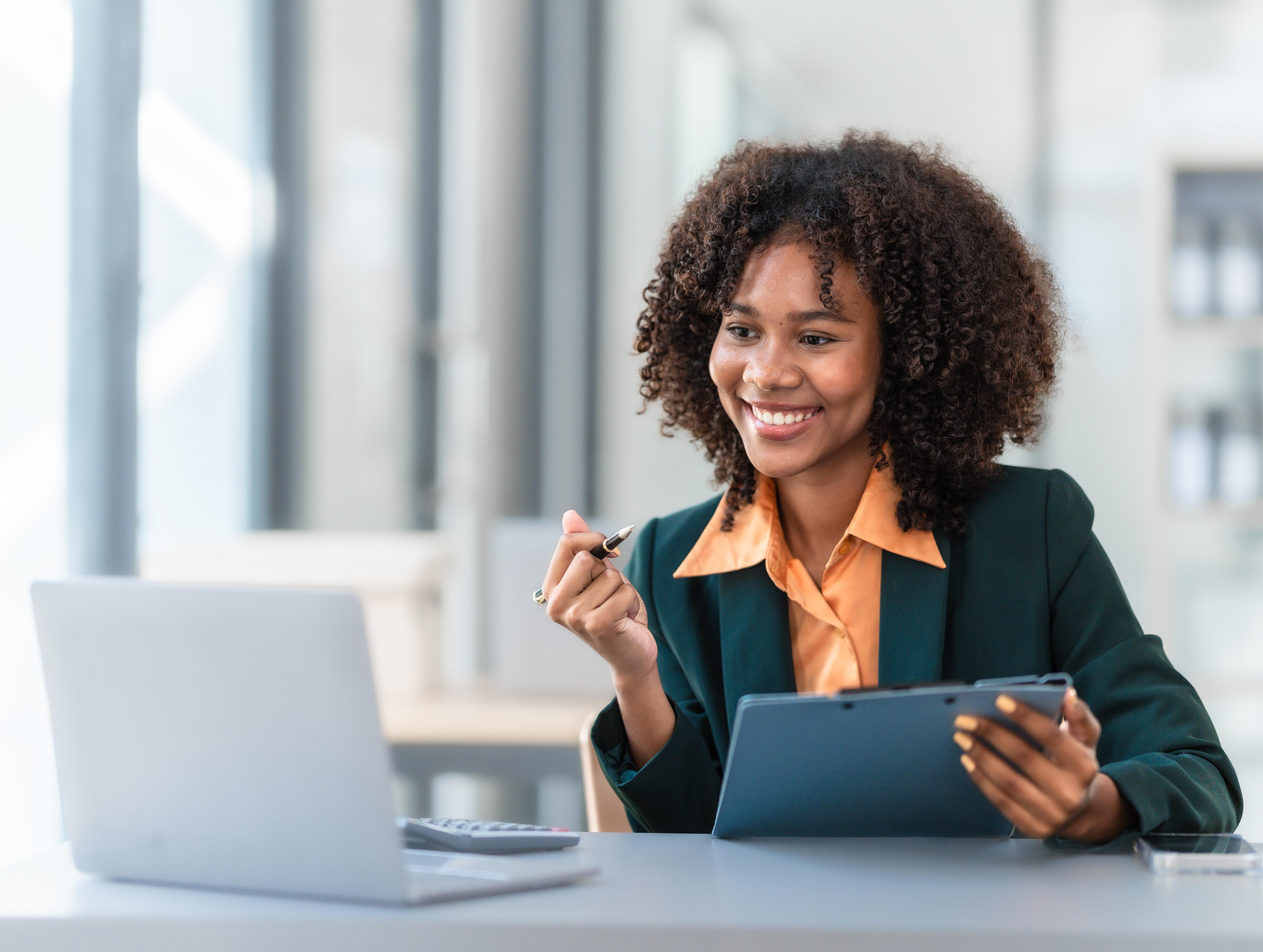 Happy businesswoman looking at her laptop