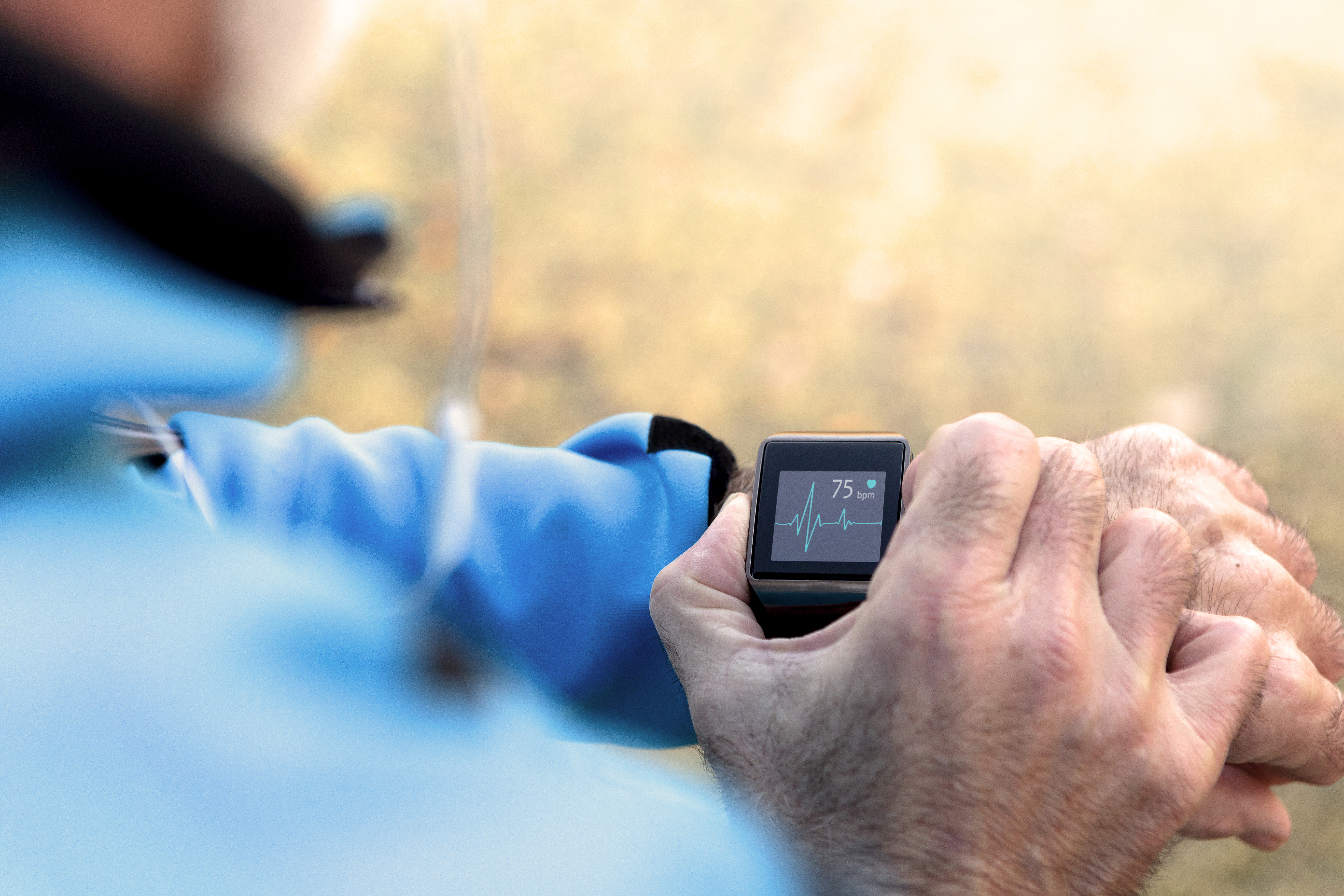 Elderly white man using smart watch measuring heart. 