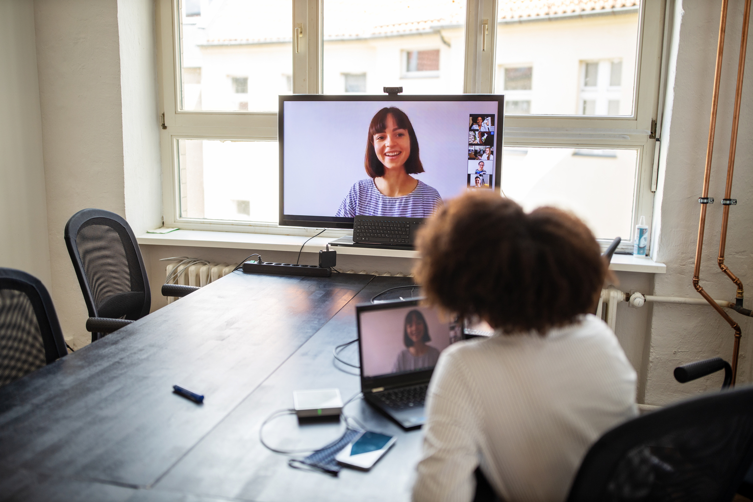 Female professionals sitting in conference room and having a video call meeting. Businesswoman on a video conference meeting at office