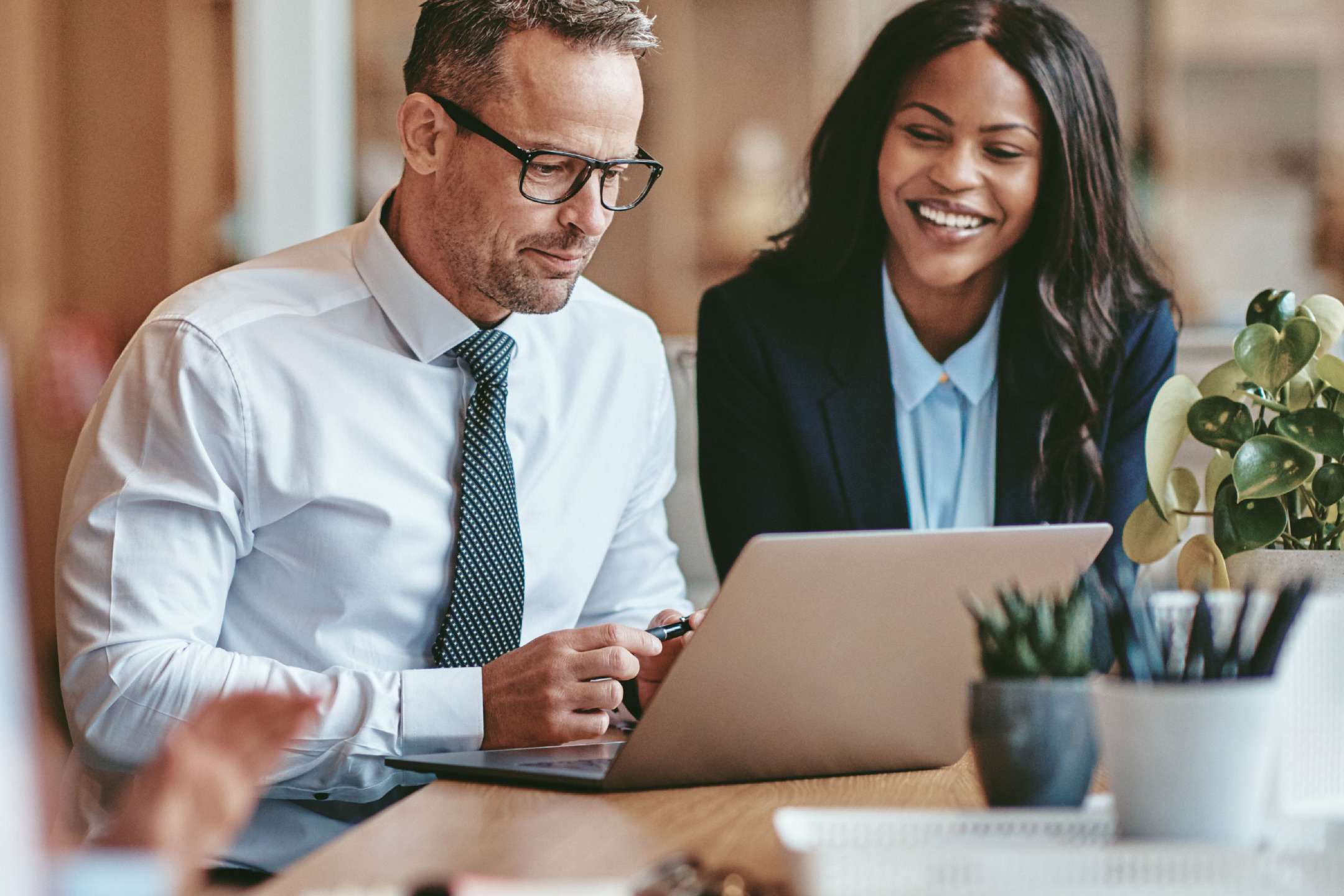 Man and woman meeting at table with laptop