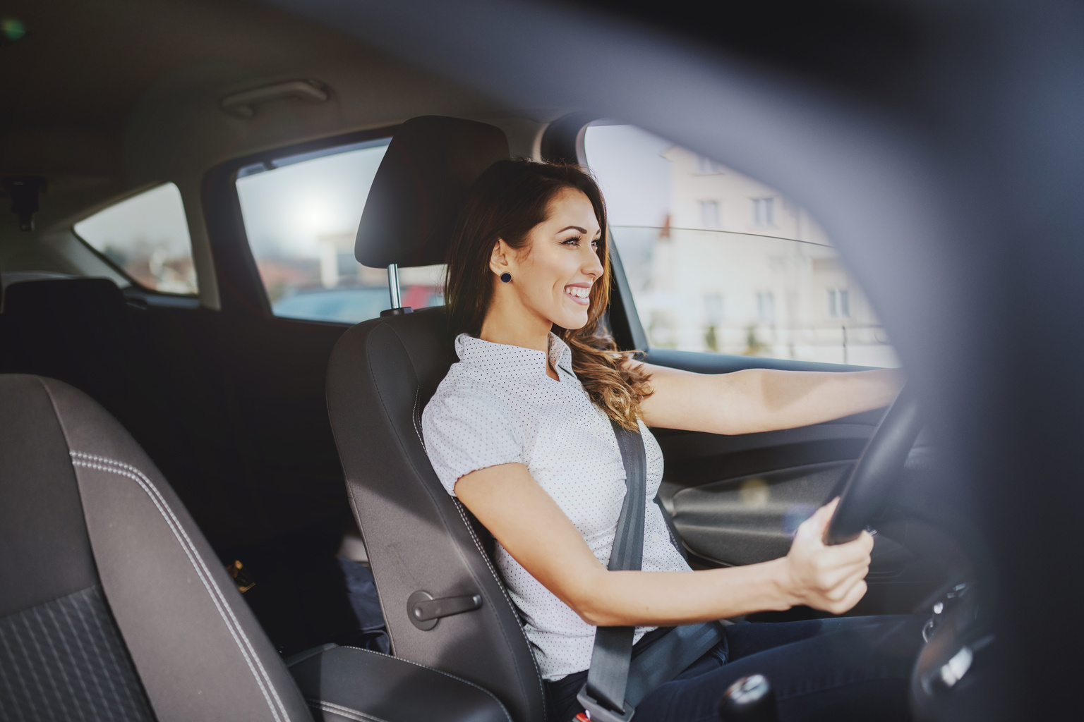 Woman in front seat of Nissan car