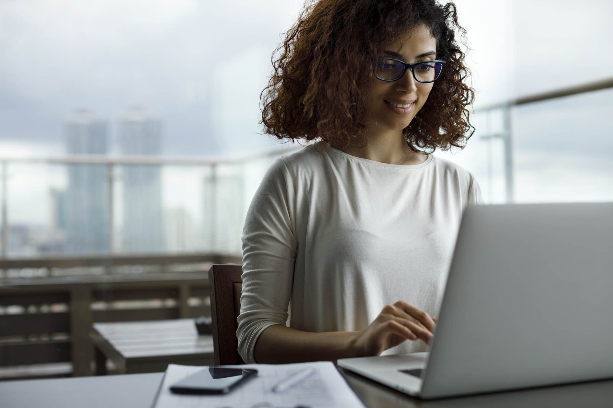 Woman working with laptop and phone