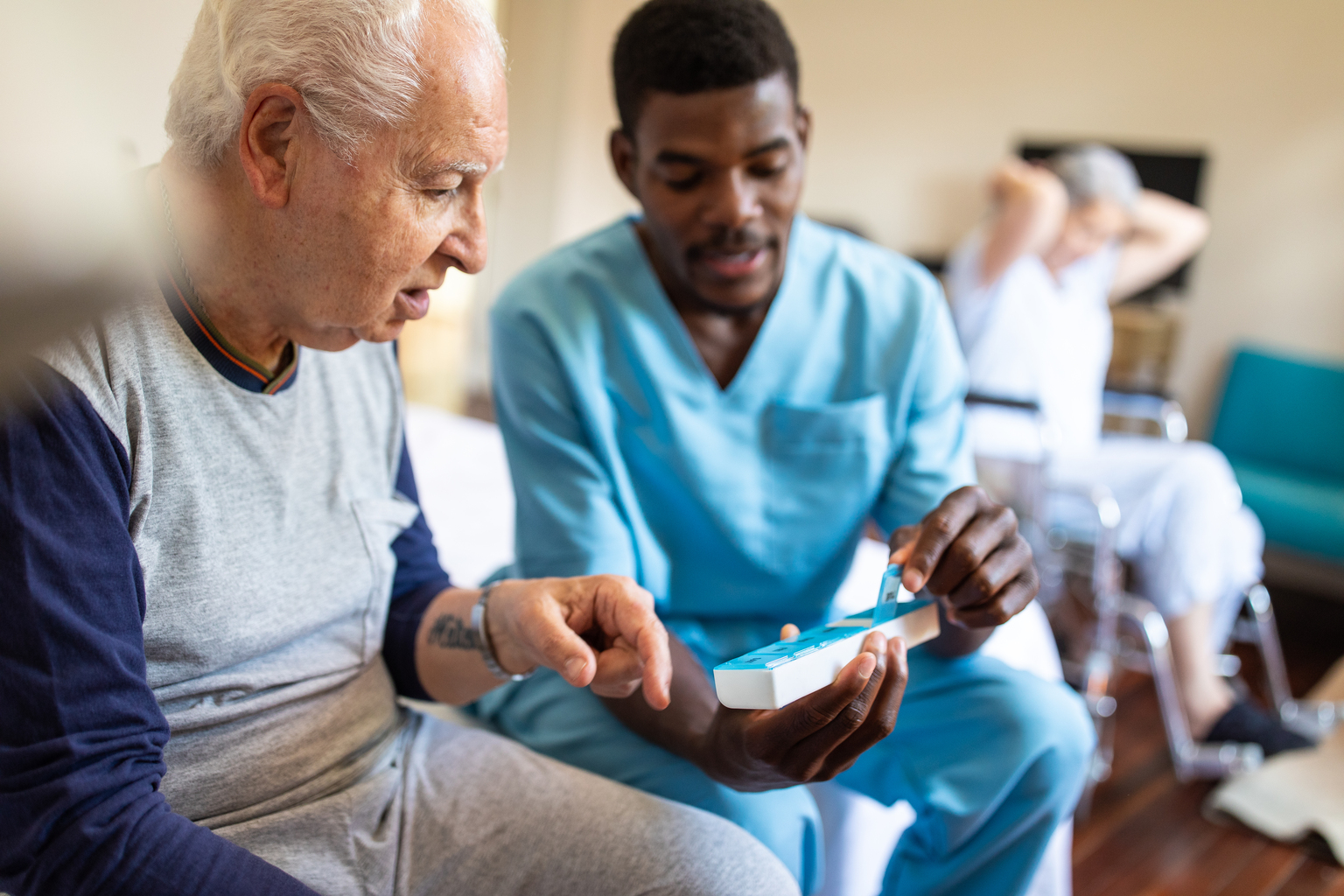 Black male nurse giving instructions to senior patient when to take his pills