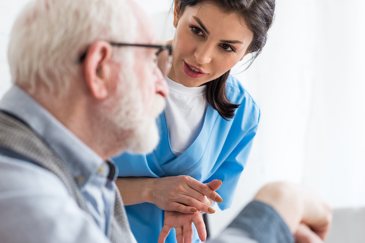 Nurse explaining something to sitting older gentleman