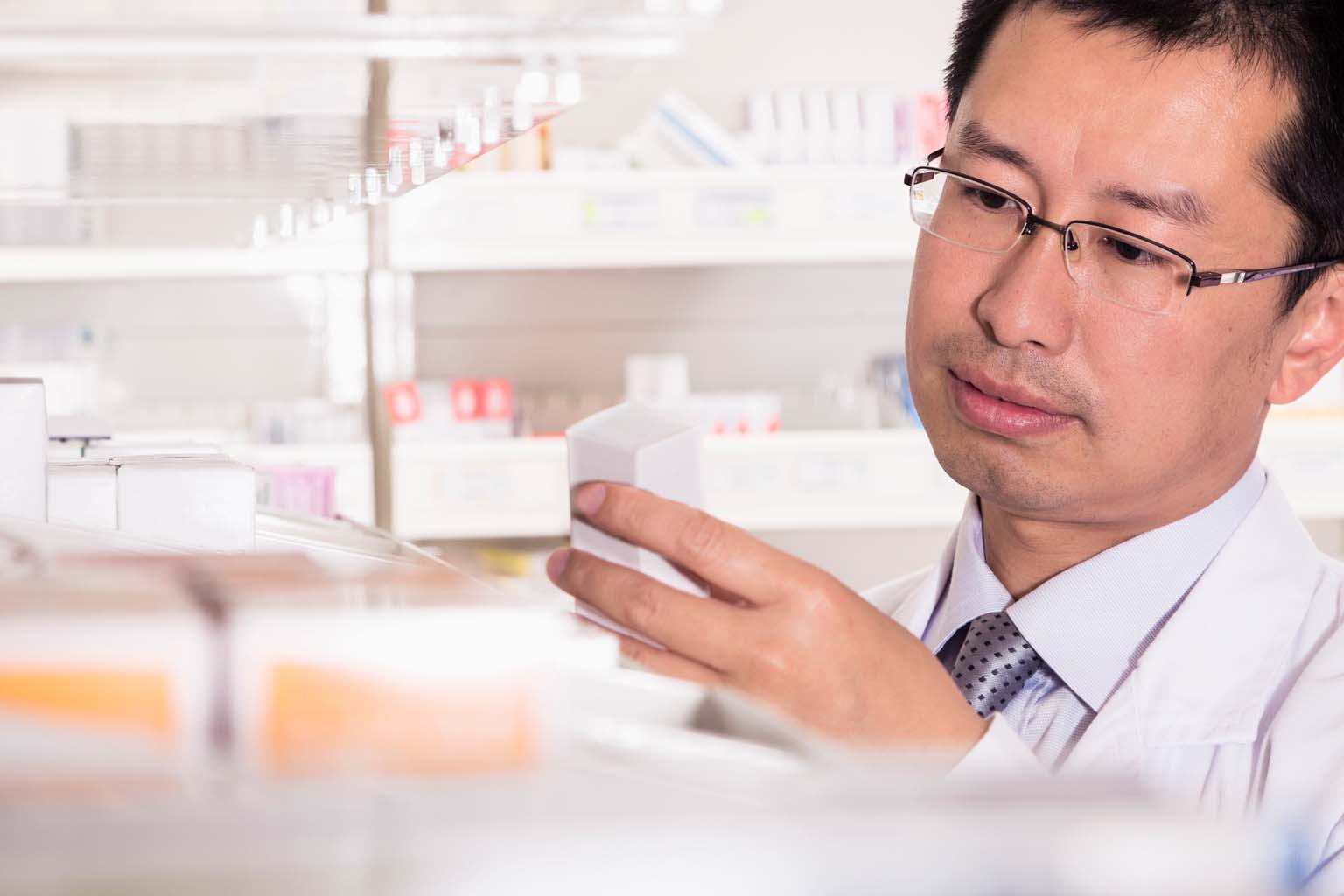 pharmacist examining medication in pharmacy