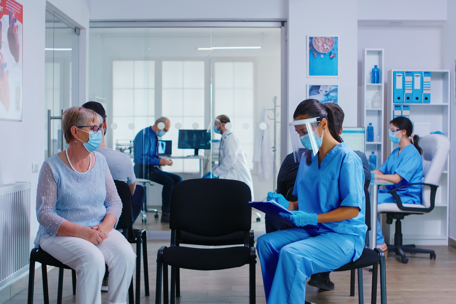 Busy healthcare office with socially distanced workers and patients