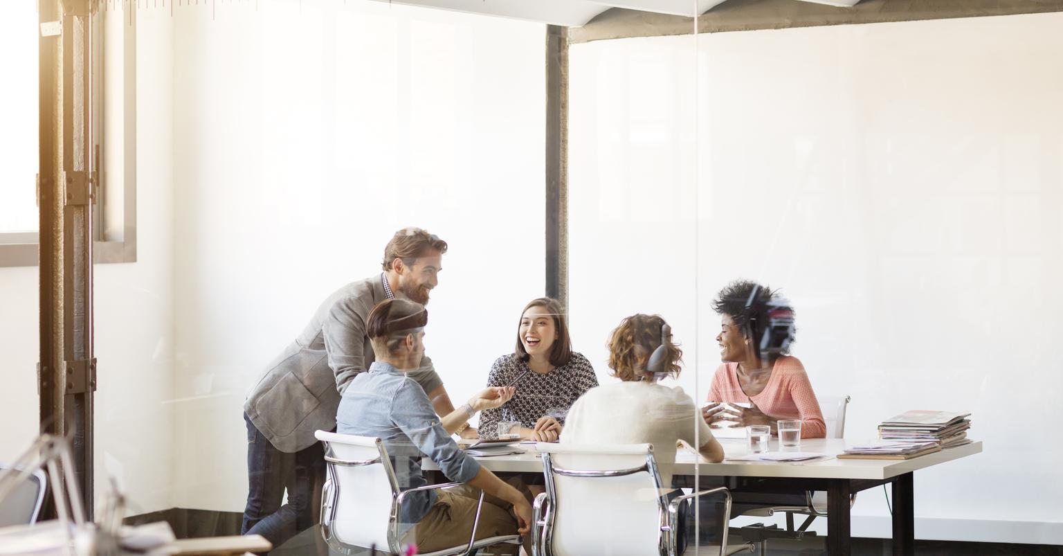 Happy young business colleagues in board room at office