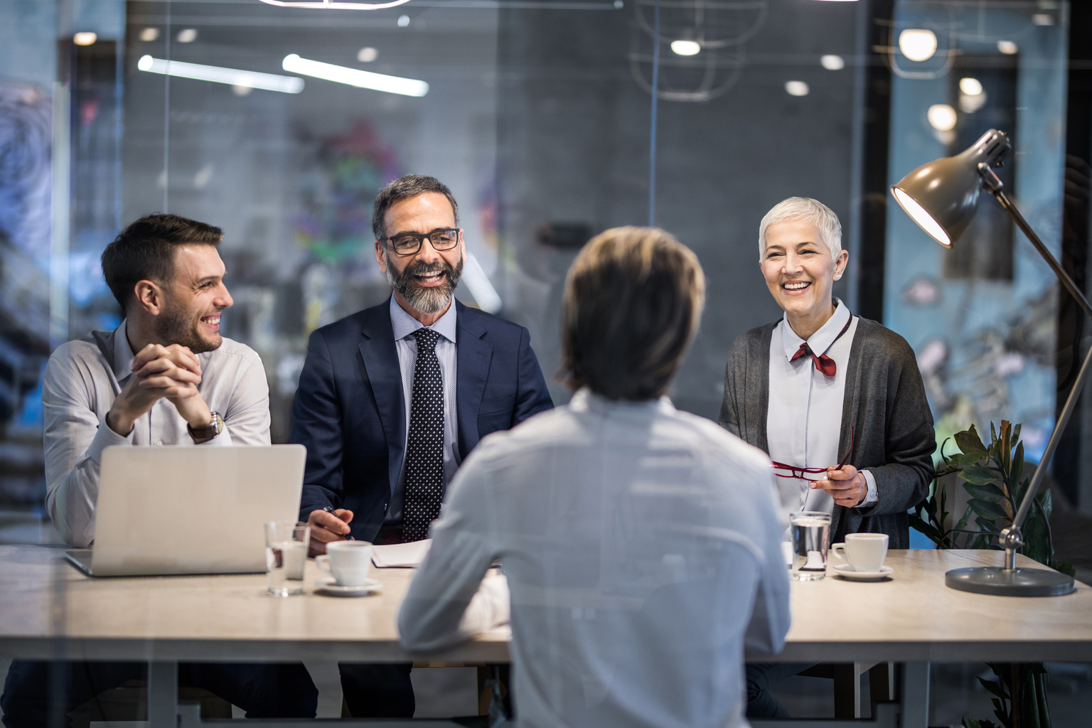 Group of business people talking to a male candidate during job interview in the office