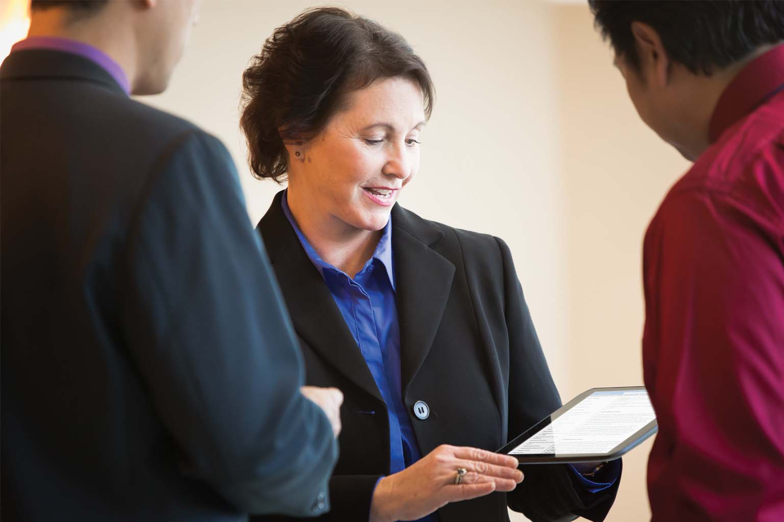 executives viewing tablet and talking