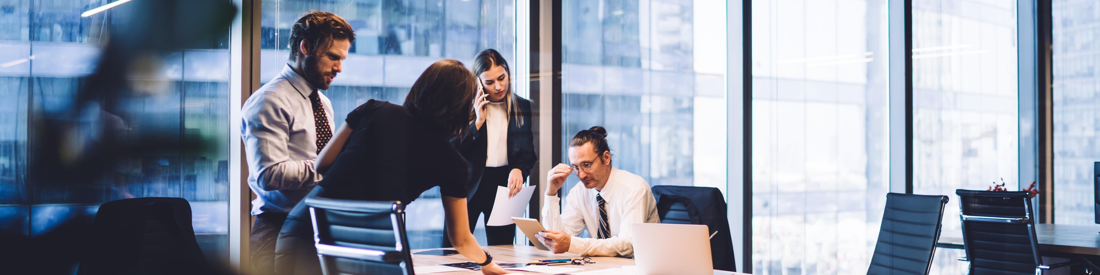 Cooperation process of professional male and female colleagues,business woman in formal suit communicate with operator via smartphone gadget while reading email from partners touch pad during teamwork