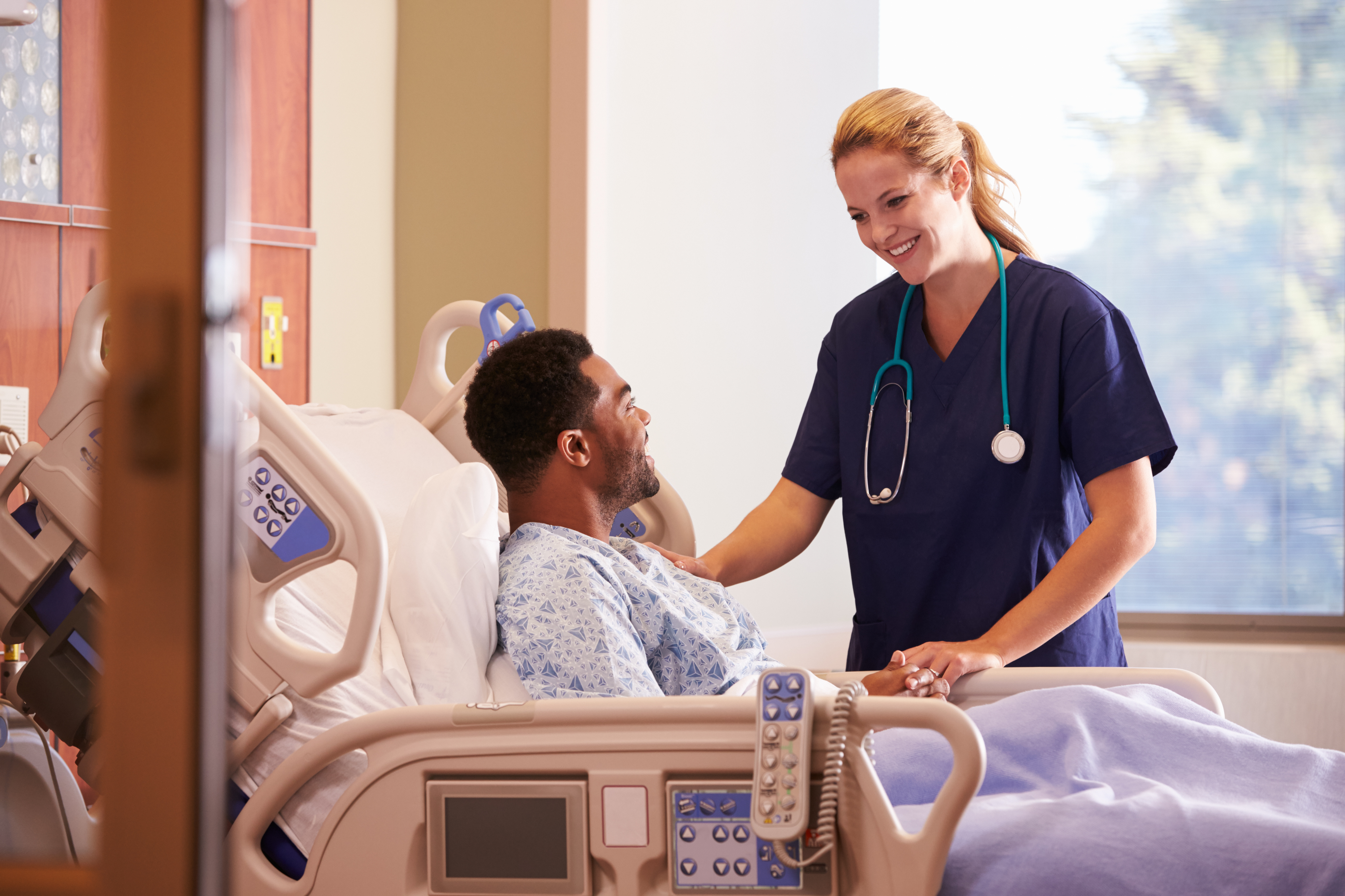 Nurse at patient bedside in hospital