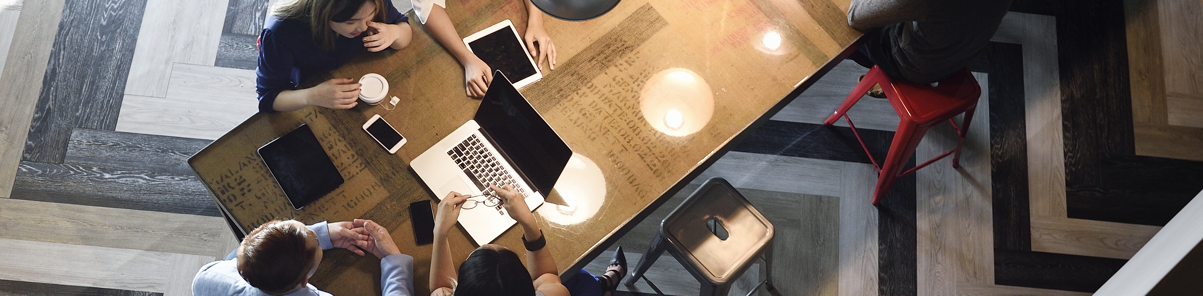 Above photography shot of a group of people collaborating on wood table with computer, ipad, and iphone. design floors, modern, Q3 2021, TAA NA US - Preparer