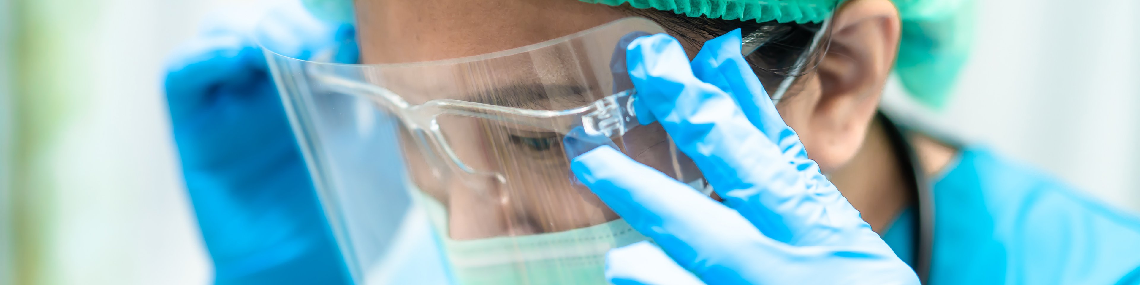 Asian doctor wearing face shield and PPE suit to check patient protect safety infection