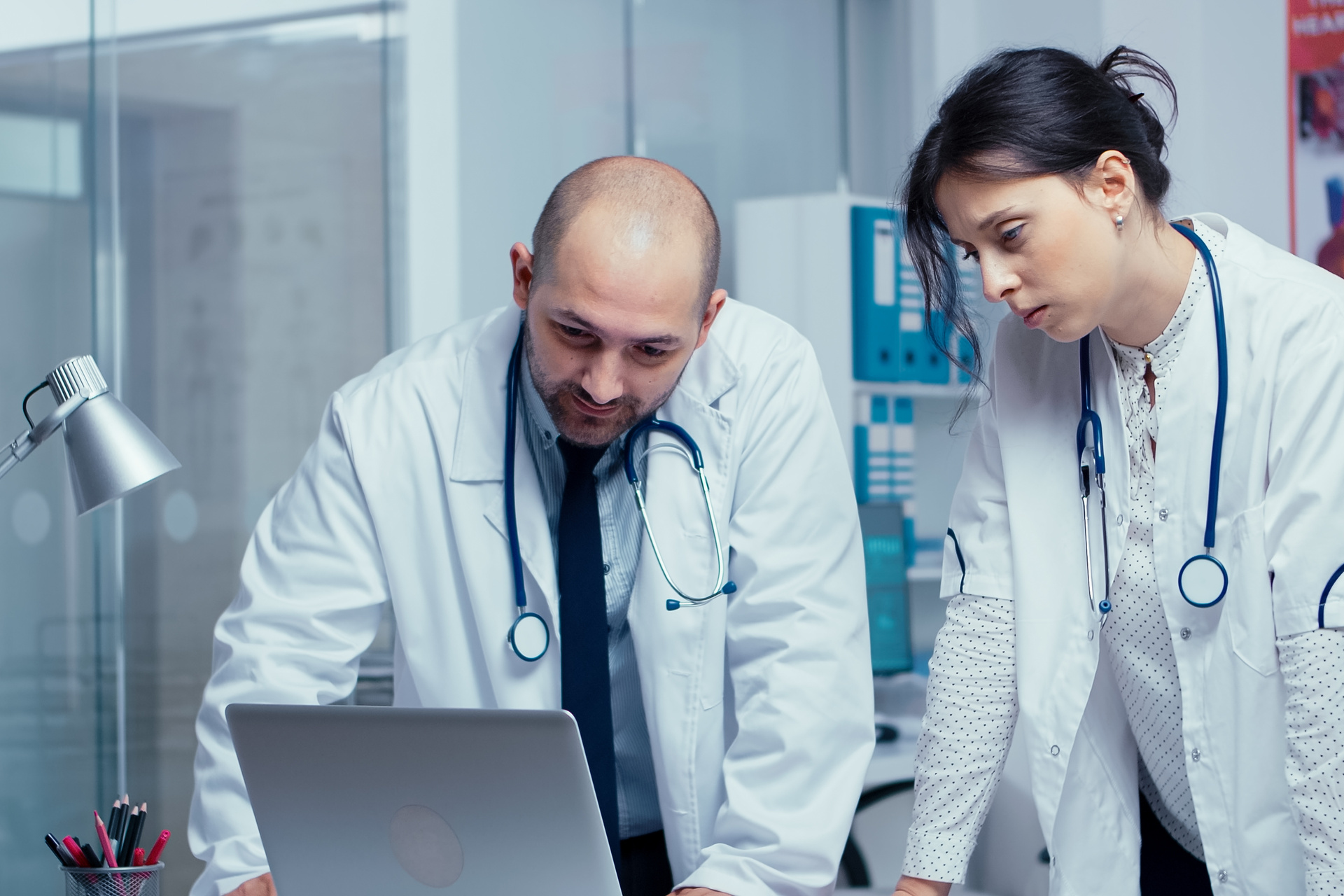 Two doctors looking at laptop in hospital setting