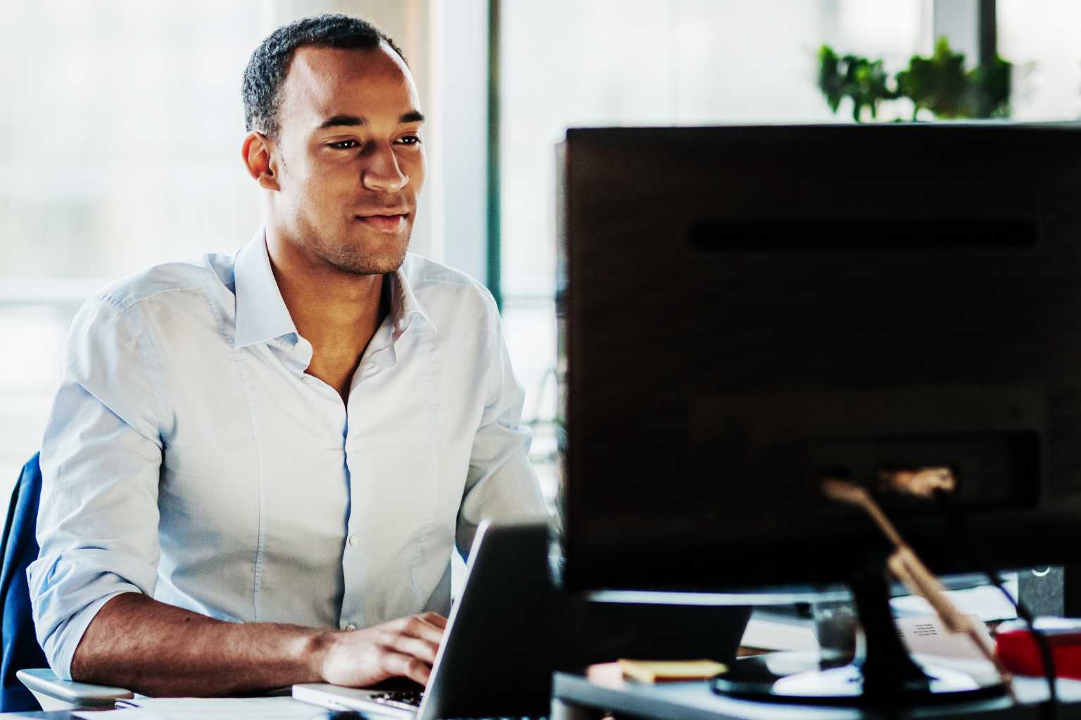 Man works at laptop with second screen