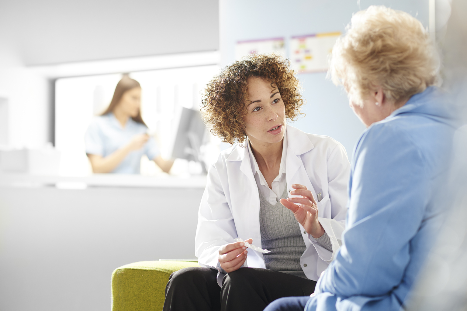 A female pharmacist consults with a senior female patient