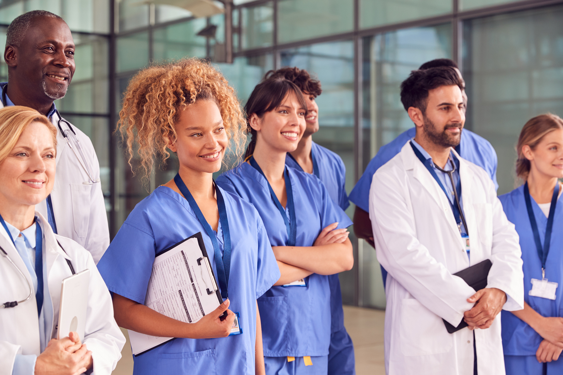 Smiling Medical Team Standing In Modern Hospital Building