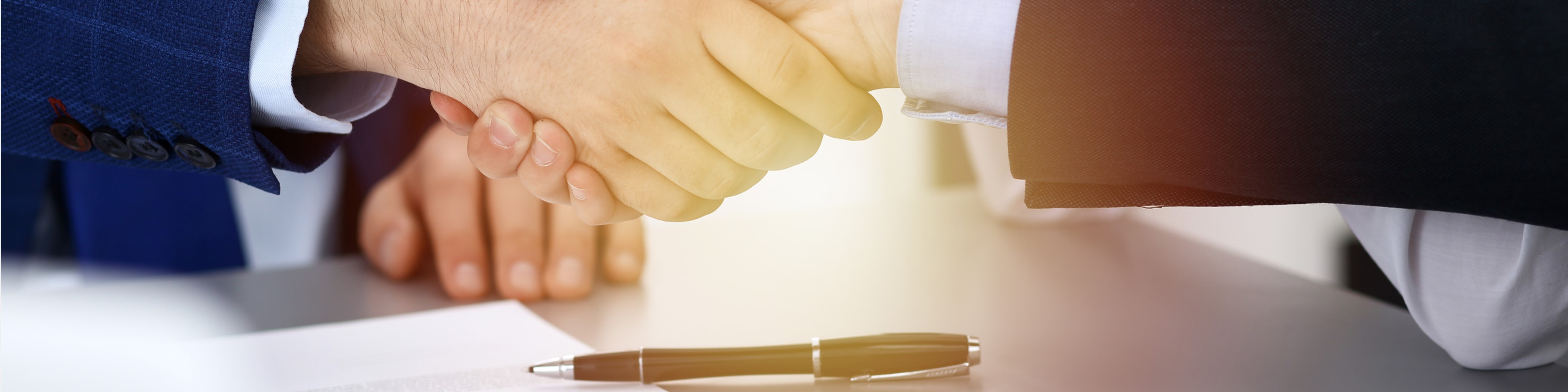 Business people shaking hands, finishing up a papers signing. Meeting, agreement and lawyer consulting concept.