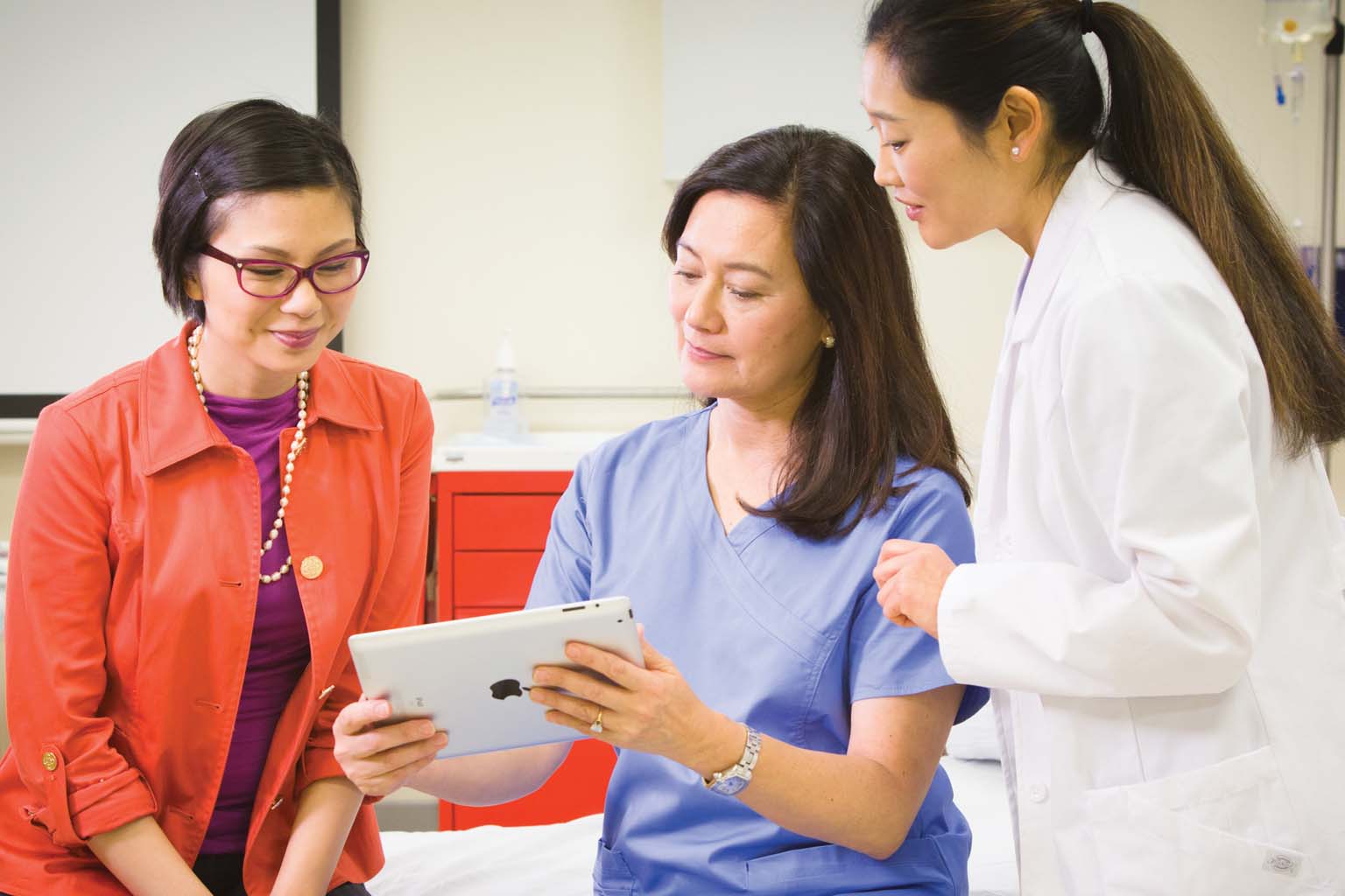 doctor with patient viewing tablet