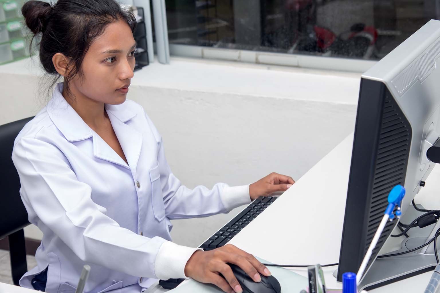pharmacist using computer in pharmacy
