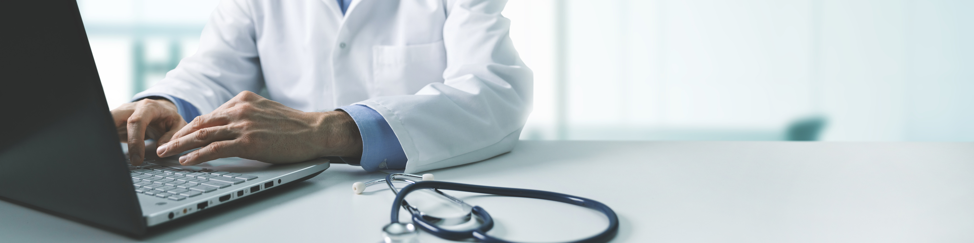 Doctor working on laptop computer in clinic office