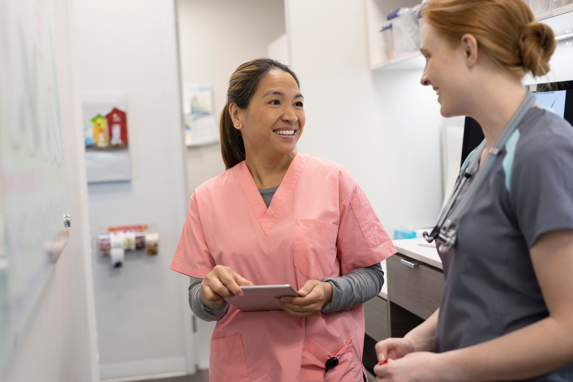 Two nurses collegially chatting at nurses station