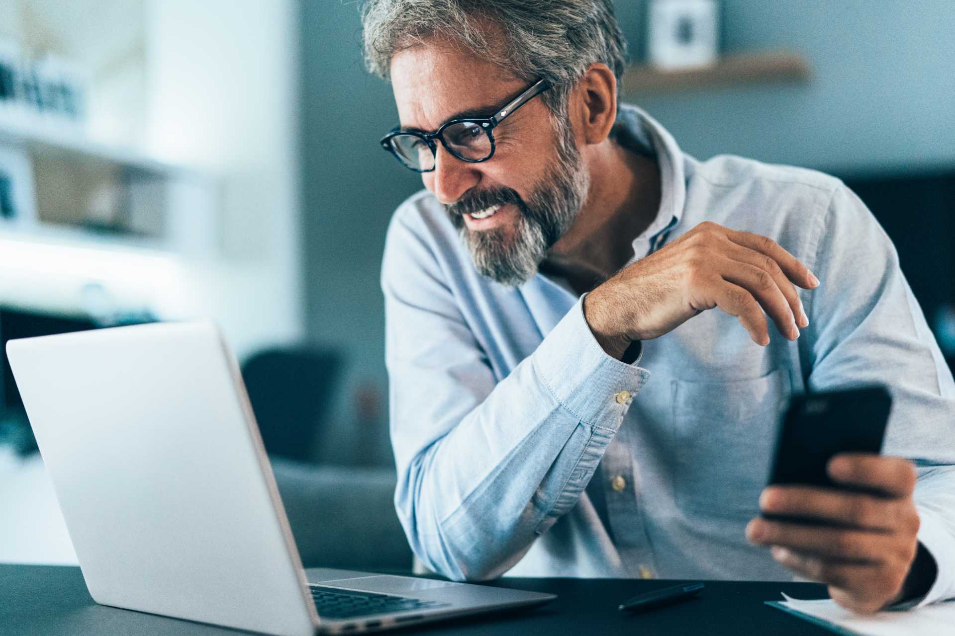 Mature man on laptop and phone 02