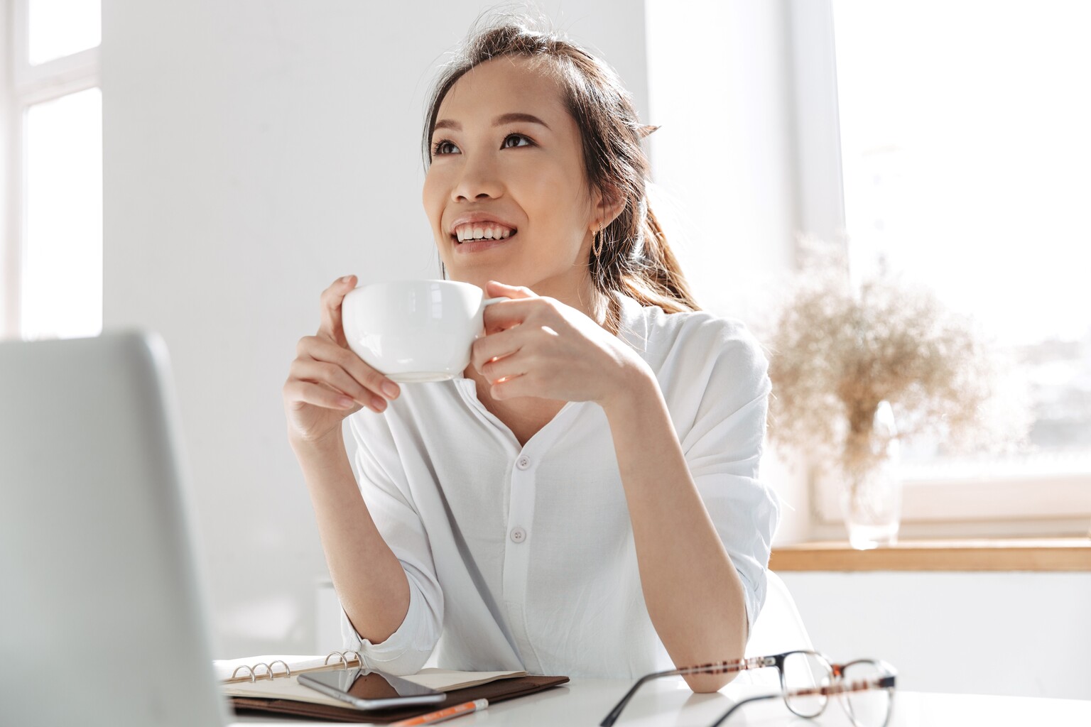 Accountant drink koffie achter laptop