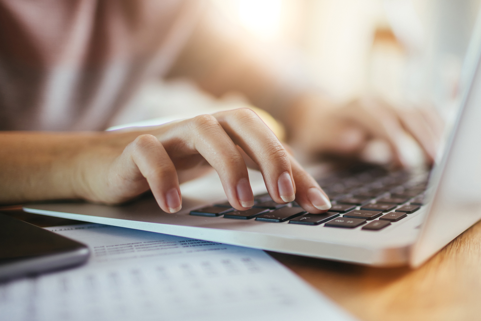 Close up image of woman typing on macbook, pink shirt, Q3 2021, TAA NA US - Preparer