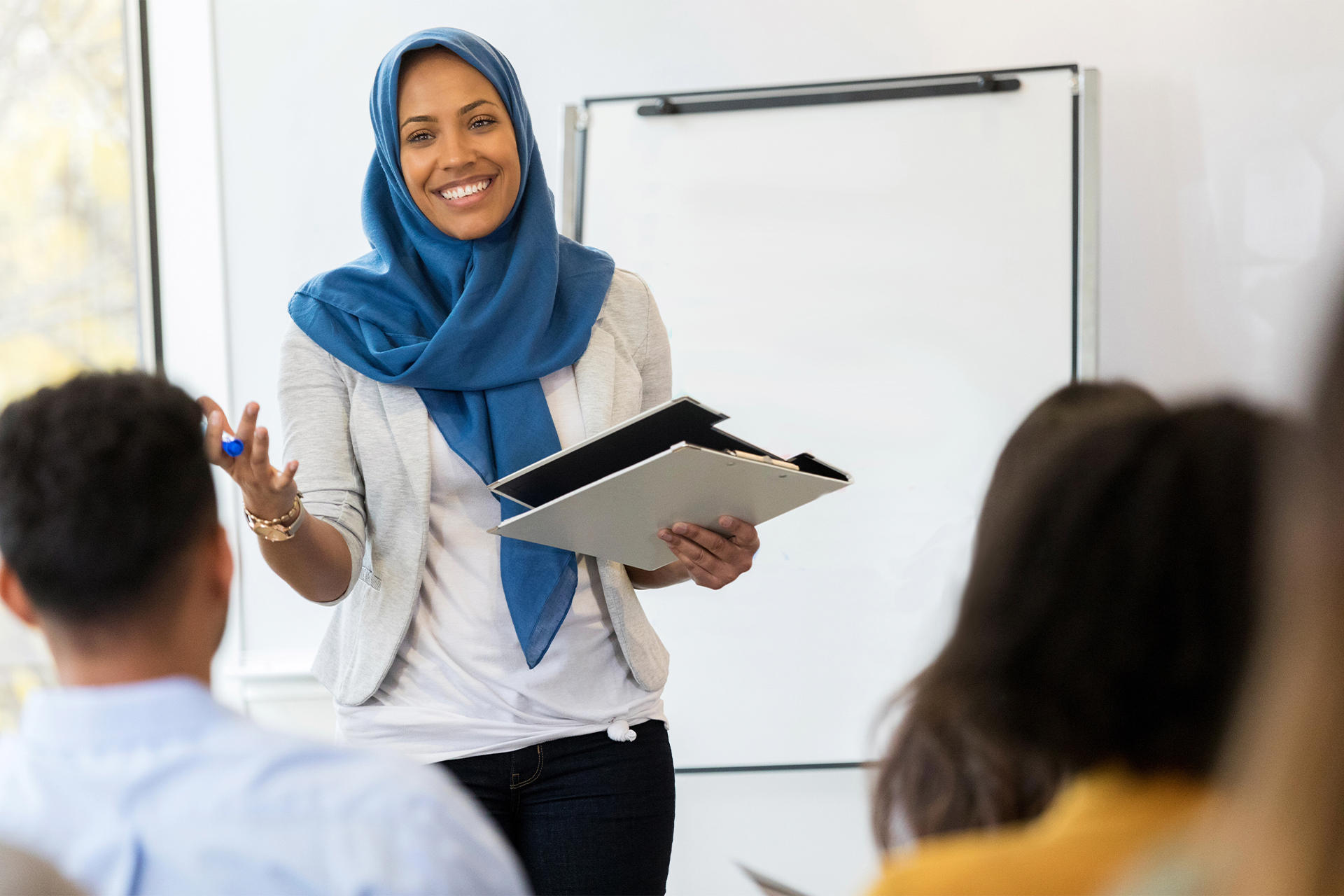 Educator standing in front of sitting group of students