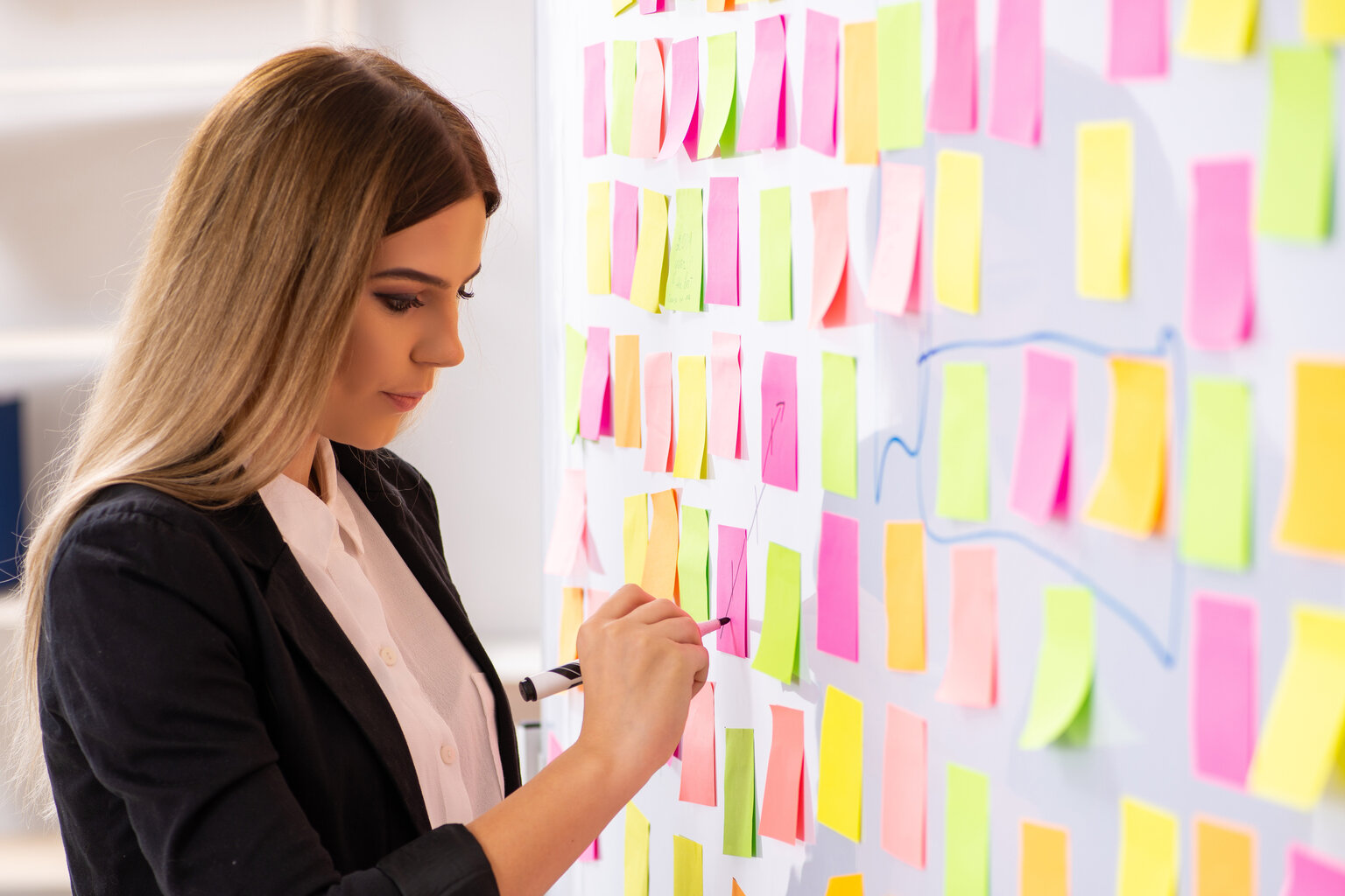 Vrouw schrijft updates op kanban bord