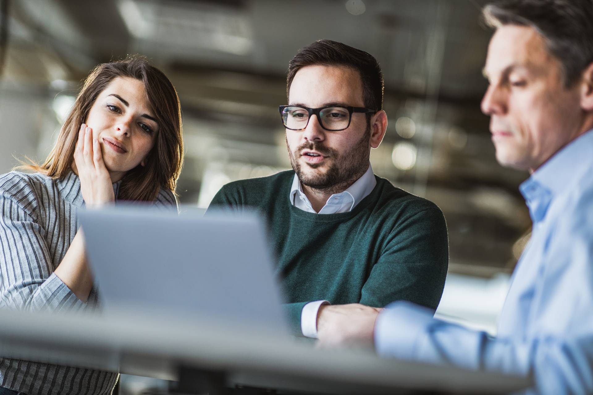 Young couple and real estate agent using laptop on a meeting in the office