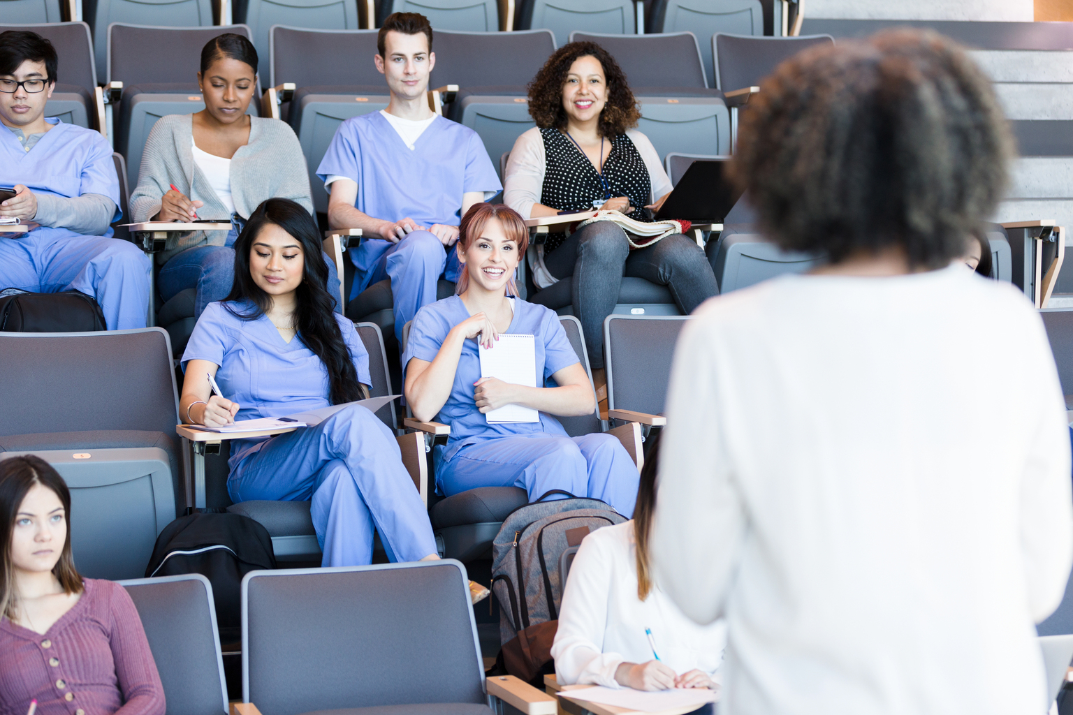 Female professor instructs medical students.