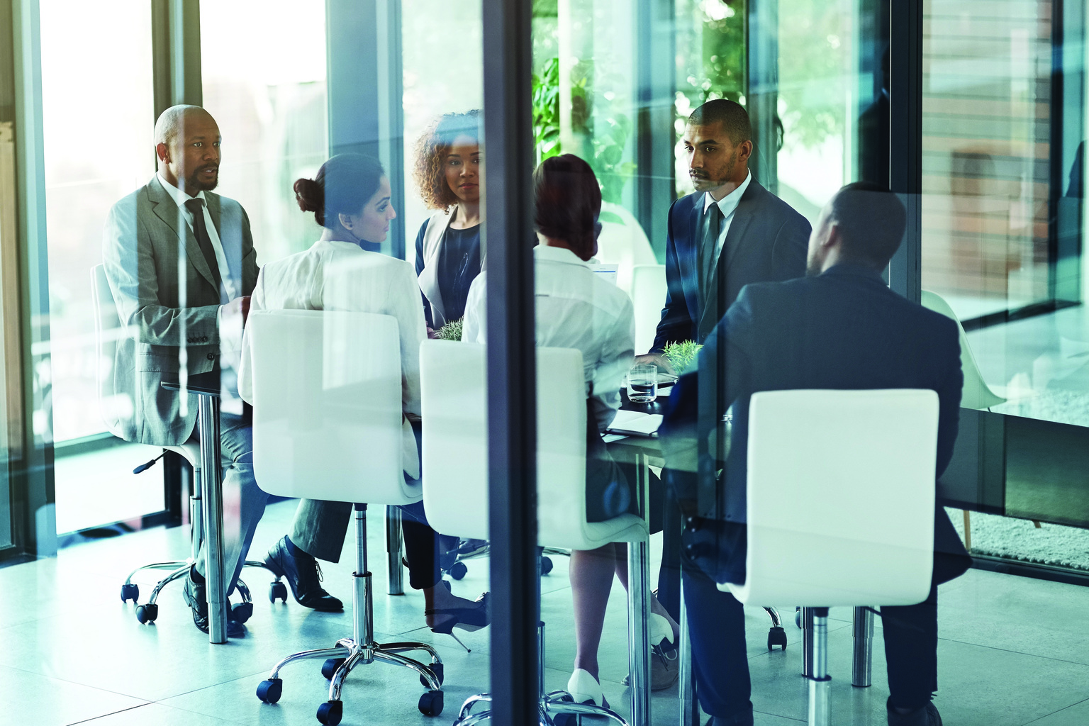 Group of business people in discussion in windowed meeting room