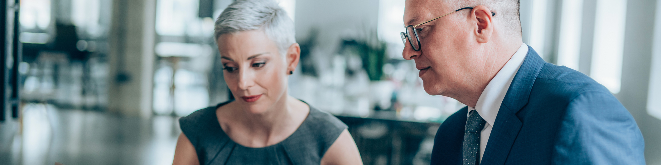 Shot of a two serious business persons talking together in a modern office