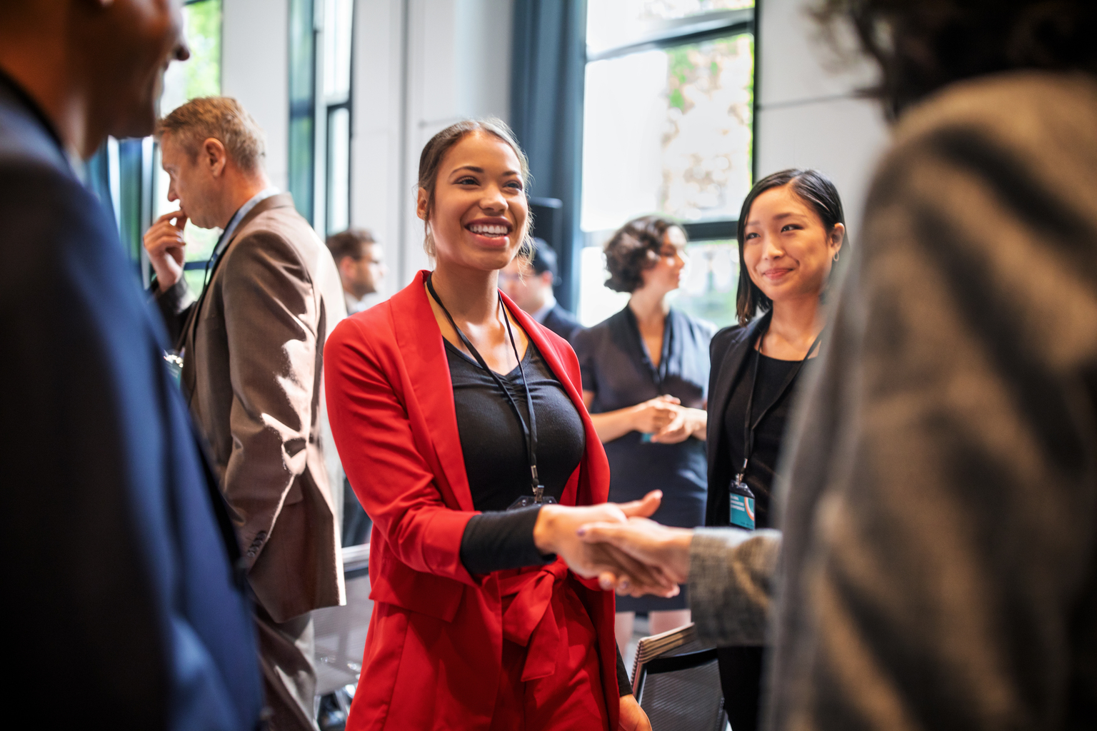 Businesswomen handshaking in auditorium corridor 